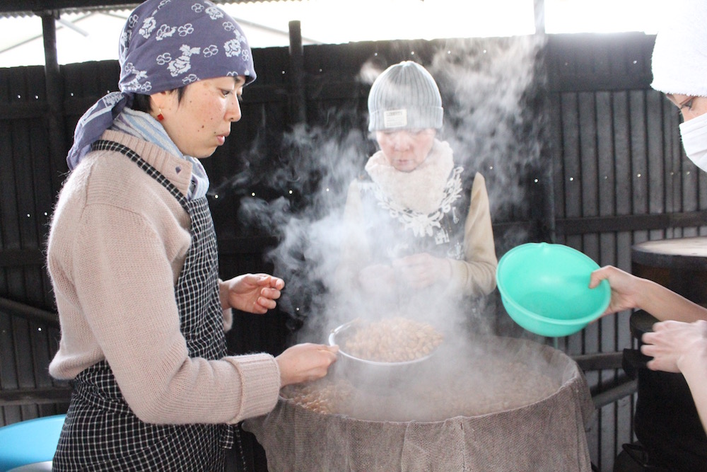 一晩水につけ、朝から釜戸で蒸してやわらかくなった大豆を桶に取り分けます
